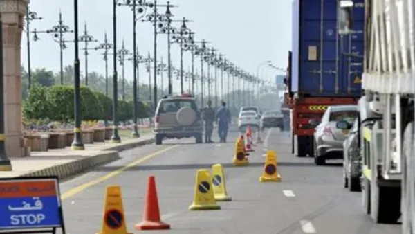 مركبات تصطف امام نقطة تفتيش على طريق في صحار العمانية
