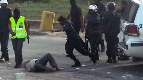 ارشيف/ رجال شرطة يعتدون بوحشية على متظاهر ملقى على الارض خلال قمع تظاهرات في المنامة عام 2011