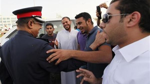 شرطي يتحدث مع محتجين لمنعهم من القيام بمسيرة اثناء مظاهرة امام مقر حزب الوفاق 
