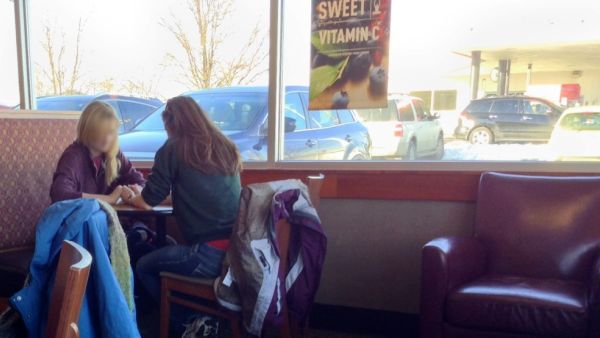 Two friends pray for each other in a Panera Bread in America. (image from Jaraad)