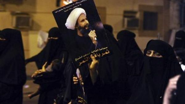 متظاهرة ترفع صورة الشيخ نمر النمر خلال احتجاج في القطيف
