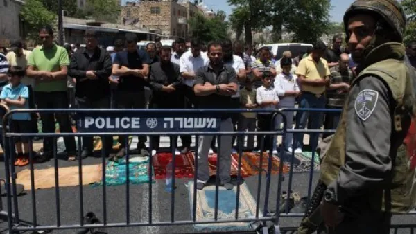 فلسطينيون يؤدون الصلاة خلف حاجز للجيش الاسرائيلي خارج المدينة القديمة في القدس 
