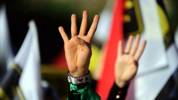 A Turkish muslim woman makes the "Rabia sign" during a rally on August 25, 2013. (AFP)