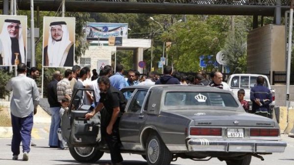 مواطنون عند معبر الرمثا قرب مدينة درعا السورية
