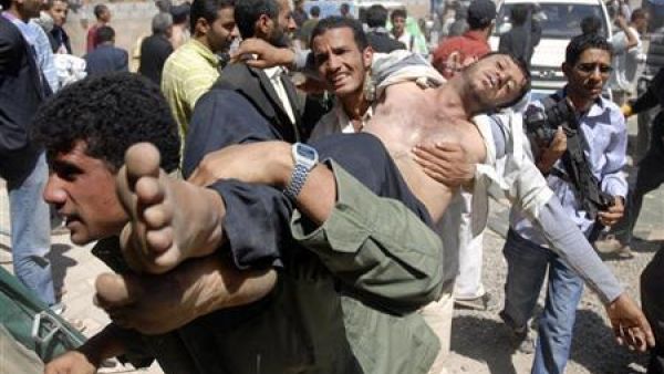 محتجون يحملون مصابا في صنعاء يوم الثلاثاء 
