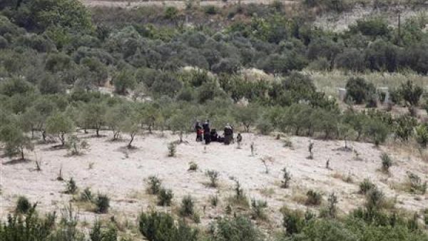 اشخاص ينتظرون العبور الى تركيا في منطقة قروية على الجانب السوري من الحدود بين سوريا وتركيا 
