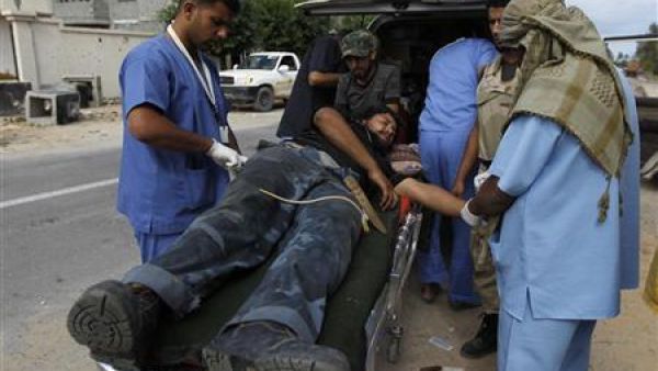 مسعفون يعالجون مقاتلا مناهضا للقذافي اصيب في القتال في وسط سرت 
