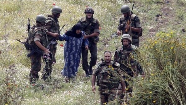 جنود سوريون يسلمون سيدة سورية مسنة الى الجيش اللبناني بعد محاولتها العبور الى شمال لبنان من منطقة العريضة السورية لملاقاة عائلتها
