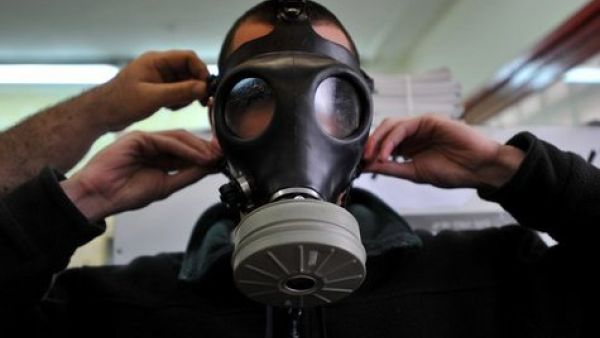 A soldier tries on a gas mask.
