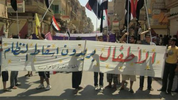 سوريون يرفعون لافتة تطالبة باسقاط النظام السوري في دير الزور شرق سوريا 