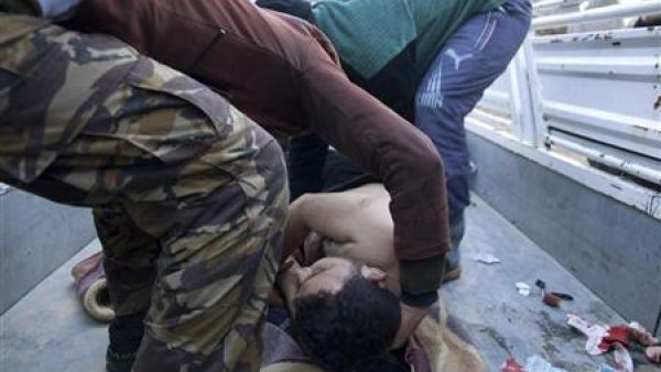 عنصران من الجيش السوري الحر يحملان جثة محتج قتل خلال مظاهرة في القصير
