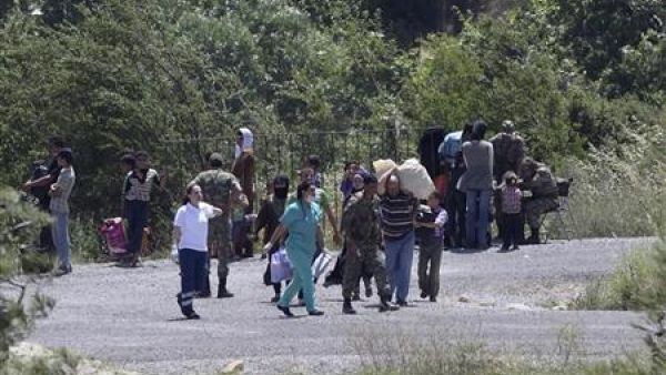 اشخاص يعبرون الحدود إلى تركيا 
