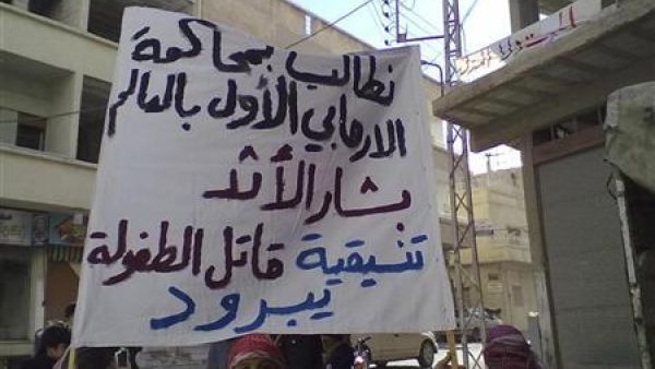 متظاهر يرفع لافتة خلال مظاهرة مناهضة للأسد في منطقة يبرود