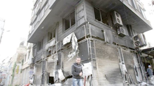 سوري يسير قرب مبنى مدمر 