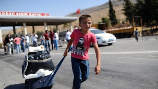 A child pulls a suitcase as Syrian refugees arrive in Turkey at the Cilvegozu crossing gate of Reyhanli, in Hatay, on August 31, 2013. (AFP)