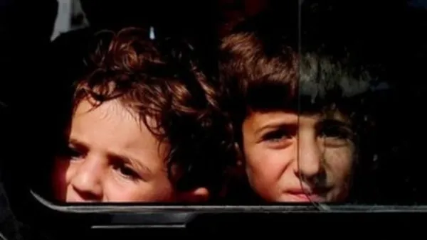 طفلان سوريان لاجئان يصلان في حافلة الى تركيا بعدما فرا مع عائلتيهما