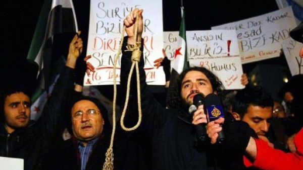 سوريون يتظاهرون استنكارا لقصف حمص امام السفارة السورية في انقرة السبت