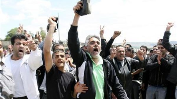 سوريون يرفعون احذيتهم ويرددون هتافات مناهضة للرئيس الاسد بعد وصولهم سيرا إلى قرية وادي خالد بشمال لبنان بالقرب من الحدود 
