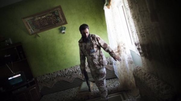 مقاتل موال للمجلس الانتقالي يقوم بتفتيش احد المنازل في حي بو سليم في طرابلس 
