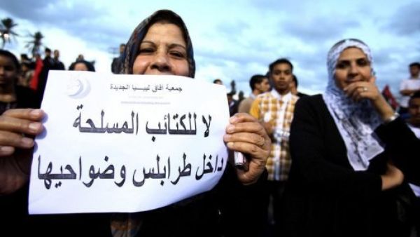 امراة ليبية ترفع لافتة خلال تظاهرة في طرابلس تطالب برحيل المليشيات المسلحة