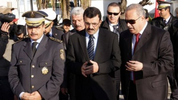 وزير الداخلية التونسي علي لعريض (وسط) بين مسؤولين في مركز للشرطة في تونس
