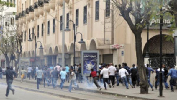 متظاهرون يفرون من قنابل الغاز التي القتها عليهم الشرطة في تونس