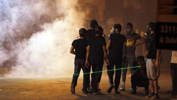 محتجون بحرينيون يضعون أقنعة واقية من الغاز أثناء اشتباكات مع الشرطة في قرية غربي المنامة