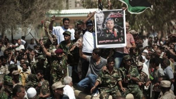 ثوار ليبيون يحملون صورة قائدهم العسكري عبد الفتاح يونس في بنغازي في 29 تموز