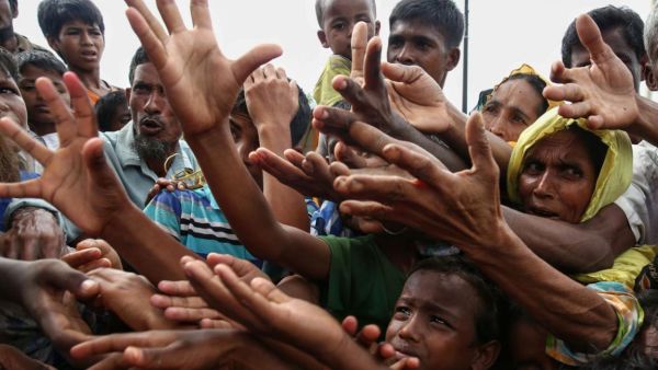 Rohingya refugees reaching for food aid at a refugee camp in Ukhiya near the Bangladesh-Myanmar border (AFP/File Photo)	