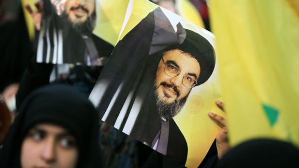 Hezbollah supporters carry posters of chief Sayyed Hassan Nasrallah at a rally. (AFP/File)