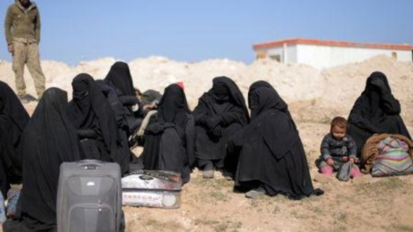 نساء ينتظرن مع أغراضهن بالقرب من الباغوز
