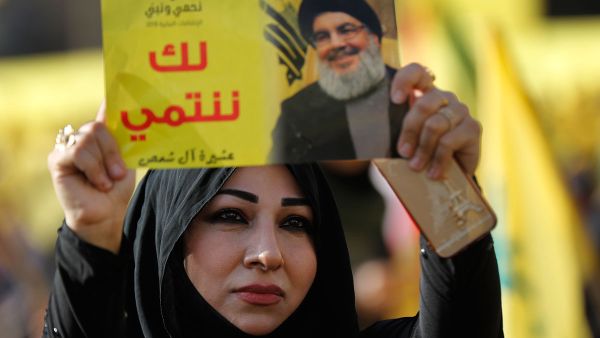 امراة من انصار حزب الله ترفع صورة امين عام الحزب حسن نصرالله