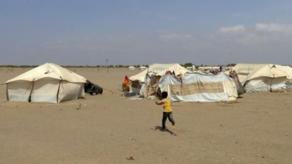 طفل يمني يركض في اتجاه خيمة داخل مخيم للنازحين في في منطقة الحديدة

