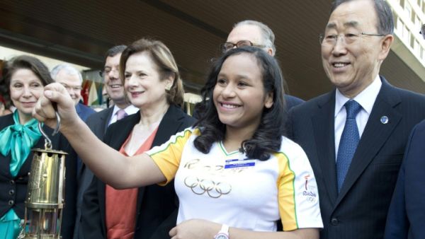 UN chief Ban Ki-moon watches as Bruna Gabriella holds the 2016 Olympic flame during a ceremony at the UN offices in Geneva, on April 29, 2016. (UN/AFP)