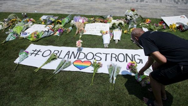 A mourner places flowers at a memorial for the 49 victims of a mass shooting at Pulse, a gay nightclub in Orlando, Florida, on June 13, 2016. (AFP/Brendan Smialowski)