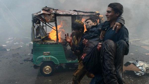 Pakistani men carry an injured blast victim at the site of a bomb explosion in the busy Kissa Khwani market in Peshawar in September. [AFP]