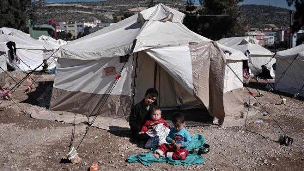 Afghan refugees rest next to their tent at the reception center for refugees in Schisto, near Athens, Greece, February 25, 2016. (AFP/File) 