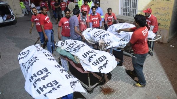 Rescuers transport the bodies of victims to a hospital in Karachi on November 12, 2016, following a suicide bombing at a Sufi shrine 750 km south of Quetta. (AFP/Rizwan Tabassum)