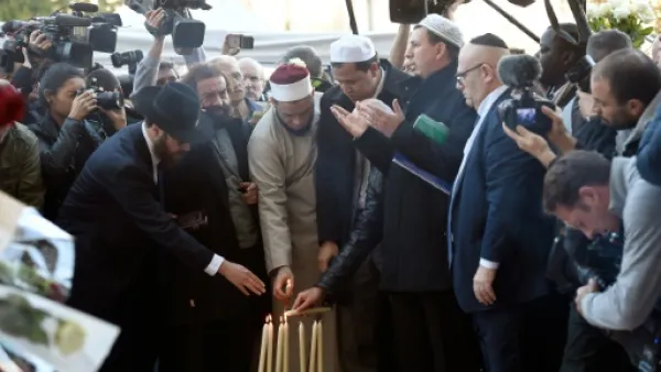 رجال دين مسلمون ويهود يضيئون الشموع امام مسرح باتاكلان
