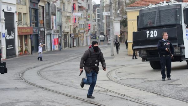 A Turkish policeman runs after an explosion on the pedestrian Istiklal avenue in Istanbul on March 19, 2016. (AFP/Bulent Kilic)