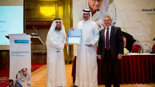 Dr. Abdullah Al Ansari (center), Deputy Chief of Medical, Academic and Research Affairs for Surgical Services, collecting the Best Department Award on behalf of the Surgery Department from Professor Janahi (left) and Professor Hillhouse (right)