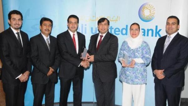 Shafqat Anwar, AUB's Deputy Group CEO, Operations & Technology, receiving the award from Ali Moosa, J.P. Morgan's Managing Director, MENA region