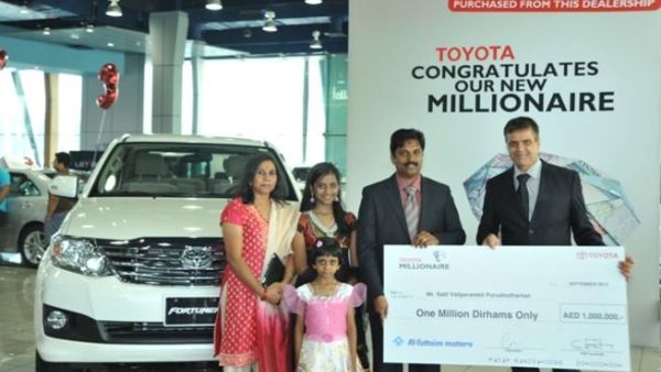 Andrew Squires presenting cheque to the Millionaire and family