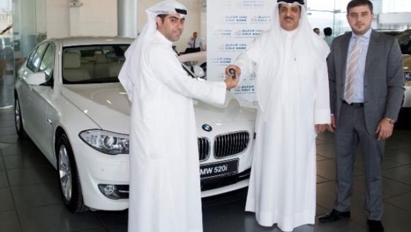 Hussain Al-Sarraf, Senior Manager, Consumer Banking Group handing over the keys to Waleed Al- Kanderi, winner of the BMW  alongside  Waleed Huwaileh, Senior Manager, Consumer Banking Group - Gulf Bank