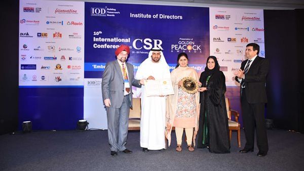 Khalil Saqer bin Gharib and Maryam Al Shamsi receive the award trophy from Mrs. Pankaja Gopinathrao Munde
