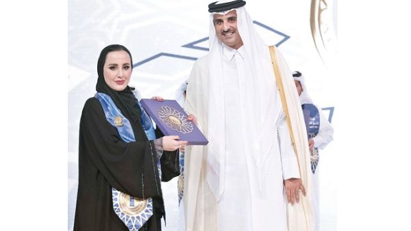 خريجة جامعة جورجتاون في قطر دانة العنزي تستلم الجائزة من أمير قطر.