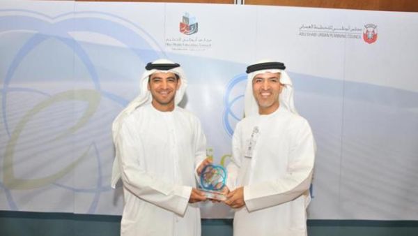 Falah Al Ahbabi, General Manager UPC, hands award to Mugheer Khamis Al-Khaili, Director General of ADEC, at the press conference