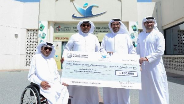 Rashed Al Ansari, General Manager of Al Ansari Exchange giving the donation to Thani Juma Berregad, Chairman of Dubai Club for people of Determination.