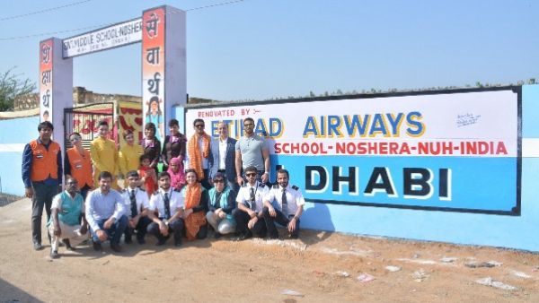 The visiting delegation pictured in front of the renovated school built in 1955