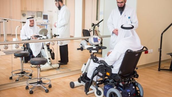 Basem Owais, Physical Therapist, conducts a physical therapy session in the QRI gymnasium with patient Jassim Mohammed Ali Abdulla